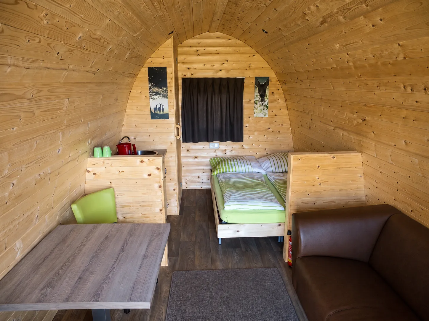 Innenansicht Woodlodge mit Bett, Sitzecke und Küchenzeile